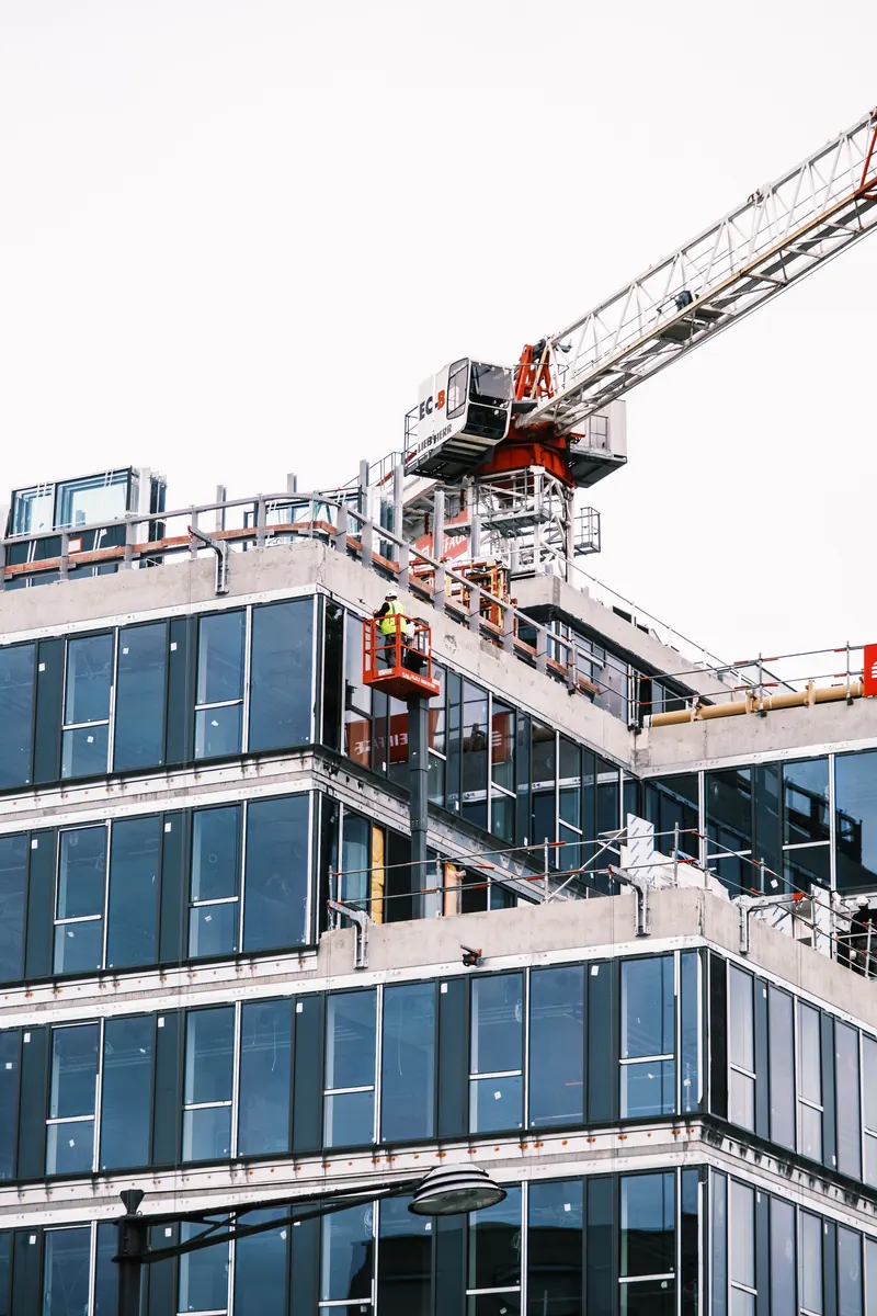 Glass curtain wall going up on a building under construction